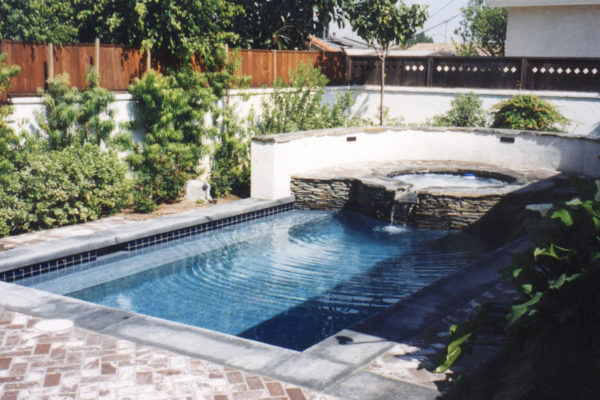 spa-with-waterfall-flowing-into-pool_riviera-pools-and-spas_premium-pool-builder-in-los-angeles-and-southern-california
